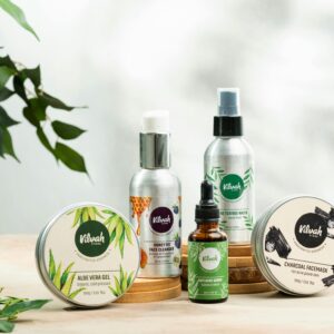 Close-up of natural skincare products including aloe vera gel and charcoal face mask.